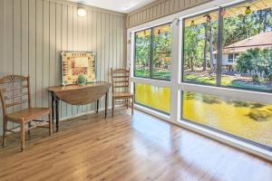 a room with a table and chairs and windows at The Pirate Den in Edisto Beach
