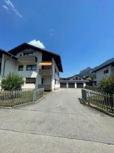 a house with a wooden fence next to a driveway at Ferienwohnung mit Bergblick in Oberammergau