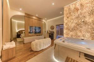 a large bathroom with a tub and a bedroom at Suite Prestige Spa Privatif D'exception in LʼIsle-Adam