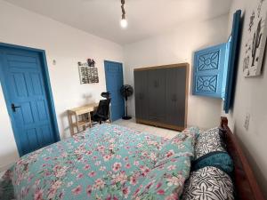 a bedroom with two blue doors and a bed at Pousada Flor de Sal in Prea +10 photos