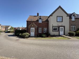 a brick house with white doors and a driveway at Anchor Down, The Bay, 2 bedrooms, patio, free parking, 2 small or 1 medium dog welcome in Filey
