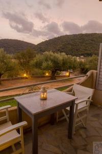 a table and chairs on a patio with a view at Nefeli Studios in Vathi