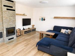 a living room with a blue couch and a fireplace at Rodinný dům Řásná u Telče in Řásná