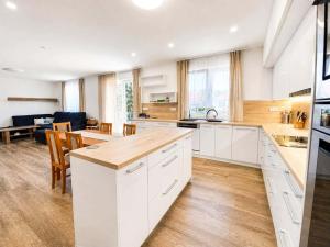 a kitchen with white cabinets and a dining room at Rodinný dům Řásná u Telče in Řásná