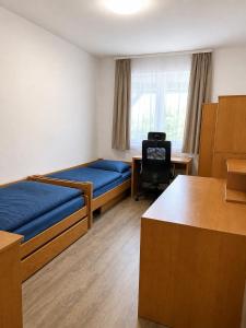 a room with two beds and a desk and a chair at Rodinný dům Řásná u Telče in Řásná