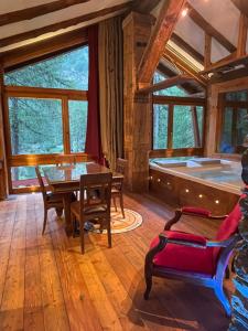 a living room with a tub and a table and chairs at Rêve sur le lac in Rhêmes-Notre-Dame