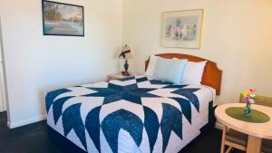 a hotel room with a bed and a table at Golden West Motel in Klamath Falls