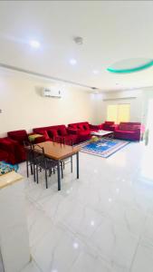 a living room with a table and red chairs at شاليهات زارا 3 in Taif