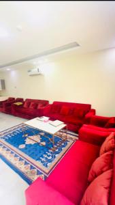 a living room with red couches and a table at شاليهات زارا 3 in Taif