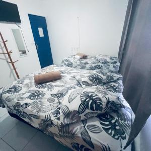 a bedroom with two beds with a black and white comforter at Pousada Dipajuçara in Maceió