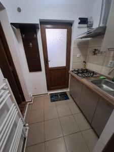 a small kitchen with a sink and a door at Strada Banu Mihalcea Nr. 150 in Constanţa +4 photos