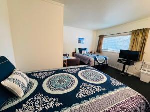 a hotel room with two beds and a window at Golden West Motel in Klamath Falls