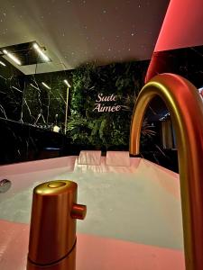a bathroom with a sink with a gold faucet at La Suite Aimée - Espace relaxant avec balnéo in Angoulême