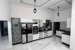 a large kitchen with white counters and appliances at Stylish Abode Guesthouse in Palatswe