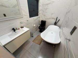 a white bathroom with a sink and a mirror at Stylish Abode Guesthouse in Palatswe