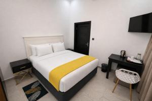 a bedroom with a bed with a yellow blanket at Stylish Abode Guesthouse in Palatswe