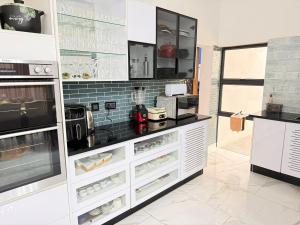 a large kitchen with white cabinets and appliances at Stylish Abode Guesthouse in Palatswe +6 photos