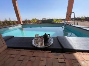 a tray of food on a table next to a swimming pool at AISHAMA Healing House in Aït Ourir +31 photos