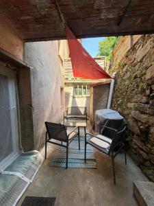 a patio with two chairs and a table in a building at Studio centre village in Bocognano