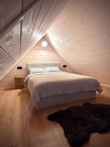 a bedroom with a large bed in a attic at Carpathian Barns in Abranka +13 photos