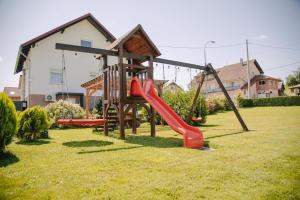 a playground with a slide in a yard at Soba i Apartman Đula in Ogulin