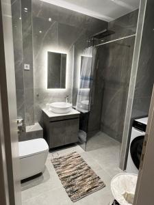 a bathroom with a sink and a toilet and a shower at GreveLuxious in Grevena