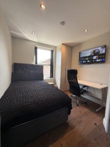 a bedroom with a bed and a desk with a computer at Aire House, Keighley in Keighley