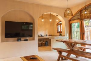 a dining room with a table and a tv in a room at Villa Hydra Private Villa with Rooftop Pool in El Cuyo