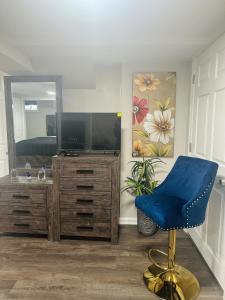 a living room with a tv and a blue chair at Elmont Escape Studio in Elmont