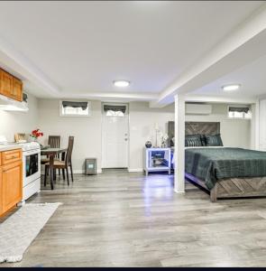 a bedroom with a bed and a kitchen with a table at Elmont Escape Studio in Elmont