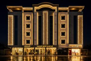 a large building with lights on it at night at قصر لوماج - احد رفيدة in Ahad Rafidah
