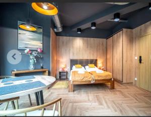 a bedroom with a bed and a table and chairs at Apartamenty Terminal Charzykowy in Charzykowy