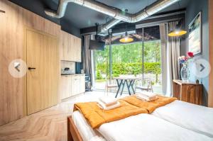 a bedroom with a large bed and a table at Apartamenty Terminal Charzykowy in Charzykowy