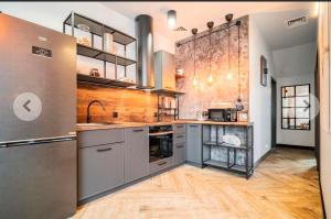 a large kitchen with stainless steel appliances and wooden floors at Apartamenty Terminal Charzykowy in Charzykowy