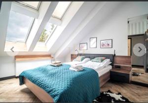 a bedroom with a large bed with a blue blanket at Apartamenty Terminal Charzykowy in Charzykowy +44 photos