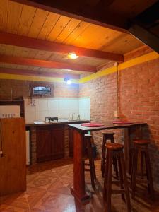 a kitchen with two bar stools and a brick wall at Cabaña en la Naturaleza, próximo a las Cataratas - Oré Lodge in Puerto Iguazú