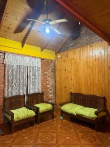 two benches in a room with a ceiling fan at Cabaña en la Naturaleza, próximo a las Cataratas - Oré Lodge in Puerto Iguazú