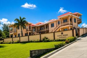 a large house with a fence in front of a yard at Castle Berry Apartments in Kingstown