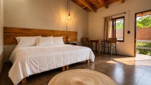 a bedroom with a large white bed and a table at Villa Maria Hotel in Valle de Bravo +12 photos