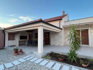 a detached house with a patio and a house at Šaravanja in Bibinje