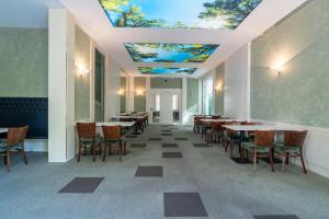 a dining room with tables and chairs and a ceiling with ceilings at Juno Suites Bremen City in Bremen