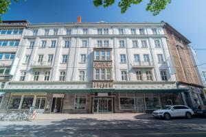 a white building with a car parked in front of it at Juno Suites Bremen City in Bremen