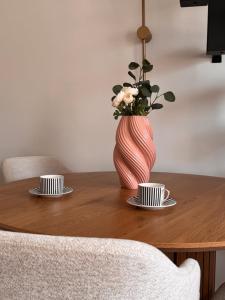 a table with two cups and a vase with flowers at Velvet Alps Bovec in Bovec +46 photos
