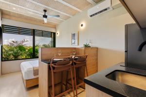 a kitchen with a sink and a table with two stools at Donceles Plaza in Cancún