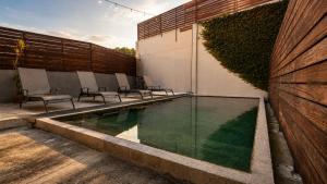a swimming pool with chairs next to a building at Villa Maria Hotel in Valle de Bravo