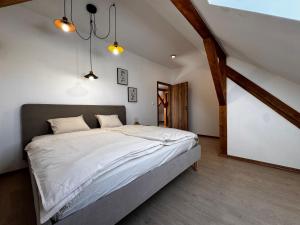 a bedroom with a large bed in a attic at Apartmán U Medvěda in Vejprty