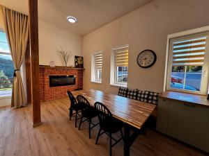 a dining room with a table and chairs and a clock at Apartmán U Medvěda in Vejprty