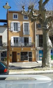a yellow building with a tree in front of it at Nidélice Chambre d'hôtes in Quillan