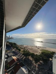 a view of the beach from the balcony of a building at Summer house in Olinda