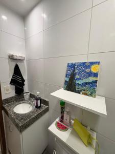 a bathroom with a sink and a painting on the wall at Summer house in Olinda +10 photos